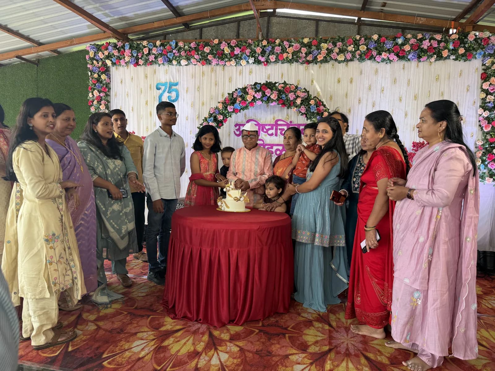 वाढदिवसाचा केक कापण्यासाठी एकत्र आलेले कुटुंब
